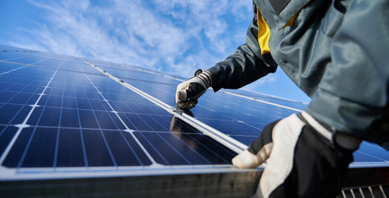 Trabajador instalando paneles solares en un tejado